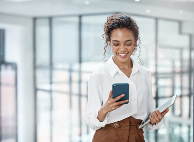 Cropped shot of an attractive young businesswoman sending a text while working in her office